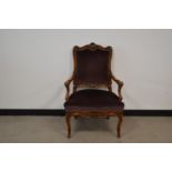 A 20th century rococo style armchair, carved back and arms, purple velvet upholstery, carved apron