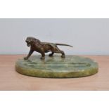 An art deco style desk tidy, bronze tiger on an oval onyx base, 25cm in length