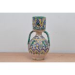 An early 20th century Persian pottery twin handled vase, baluster form with a circular rim,