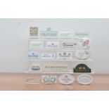 A collection of British ceramic advertising plaques, including Royal Worcester, Wedgwood, Crown