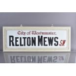 A City of Westminster glass road sign, for Relton Mews, S.W., black and red lettering on white