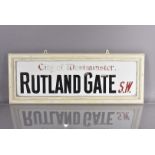 A City of Westminster glass road sign, for Rutland Gate, S.W., black and red lettering on white