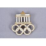 A 1936 Berlin Olympic gilt and white enamel badge, stamped with maker's name 'Deschler Munchen,