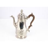 A Georgian style coffee pot, 25cm high and 24.65 ozt, with raised floral and scroll decoration and