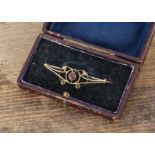 An Edwardian 15ct gold tourmaline and seed pearl Art Nouveau open work brooch, 4.3 cm by 1.2 cm,