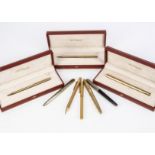 A set of S.T. Dupont gilt pens and a pencil and other pens, each boxed and gold plated, with a biro,