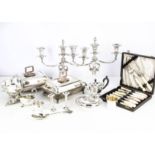 A collection of silver plate, including a muffin dish, a pair of candelabra uppers, a bachelor
