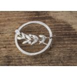 A continental white metal 14K marked circular brooch, of open worked leaf design, with white CZ