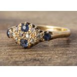 An 18ct gold diamond and sapphire ring, of flattened form with four cushion cut blue sapphires