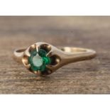 A 10k marked yellow metal garnet topped doublet claw set ring, circular claw set green stone, ring