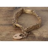 A 9ct gold gate linked bracelet with padlock clasp, textured links, with curved tops, with a fine