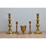 A collection of brass items, comprising two pairs of candlesticks, the tallest 27cm high, a brass