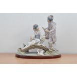 A Lladro ceramic figural group, two Japanese ladies on a bridge with flowers, the bridge with a