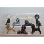 A collection of assorted poodles figurines, including pottery examples, cast metal, two carved