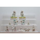 A collection of ceramic poodles, comprising a pair of Dresden examples, on green and gilt
