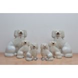 Three graduated pairs of late 19th century ceramic Staffordshire dogs, the largest pair 24.5cm high,