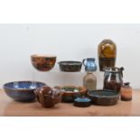 A collection of studio pottery, including stoneware and terracotta examples, bowls, vases, a jug,