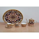 A miniature Imari Royal Crown Derby tea set for one, comprising a teapot and cover, cup and saucer