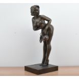 A cast metal sculpture of a suggestive nude lady, on a rectangular base, with some wear to the