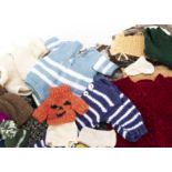 A large selection of hand knitted clothes for dolls and teddy bears, including thirty two cardigans,
