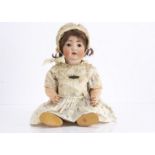 A Koning & Wernicke character baby, with brown lashed sleeping eyes, brown mohair wig, bent-limbed