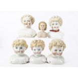 Six blonde haired shoulder heads, four china, one named Esther -7in. (17.5cm.) high; and two