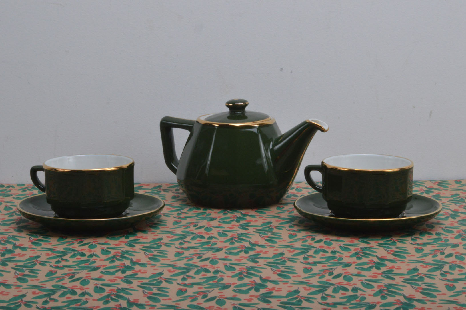A 20th century tea for two set, green with gilt design, comprising a teapot and cover and two cups