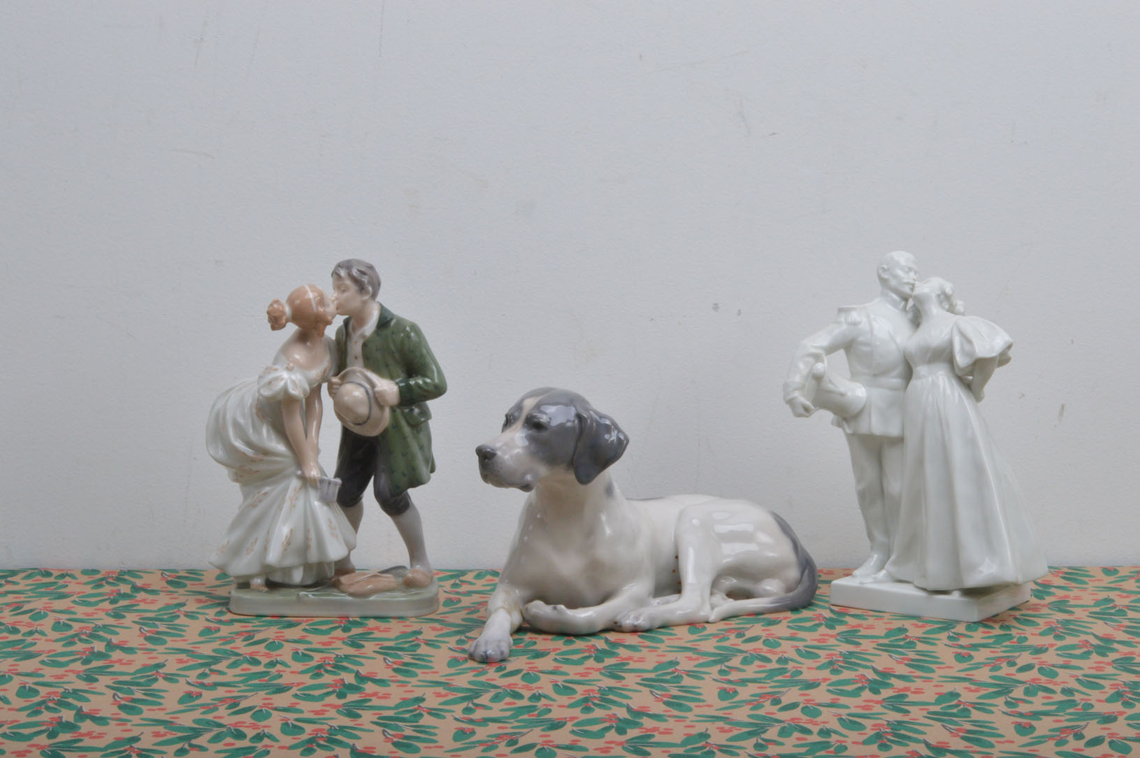 Two Royal Copenhagen porcelain figures, modelled as coouples both 'Kissing' on a solider and his