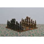A 20th century African primitive hand carved chess set, hardstone, some wear commensurate with age