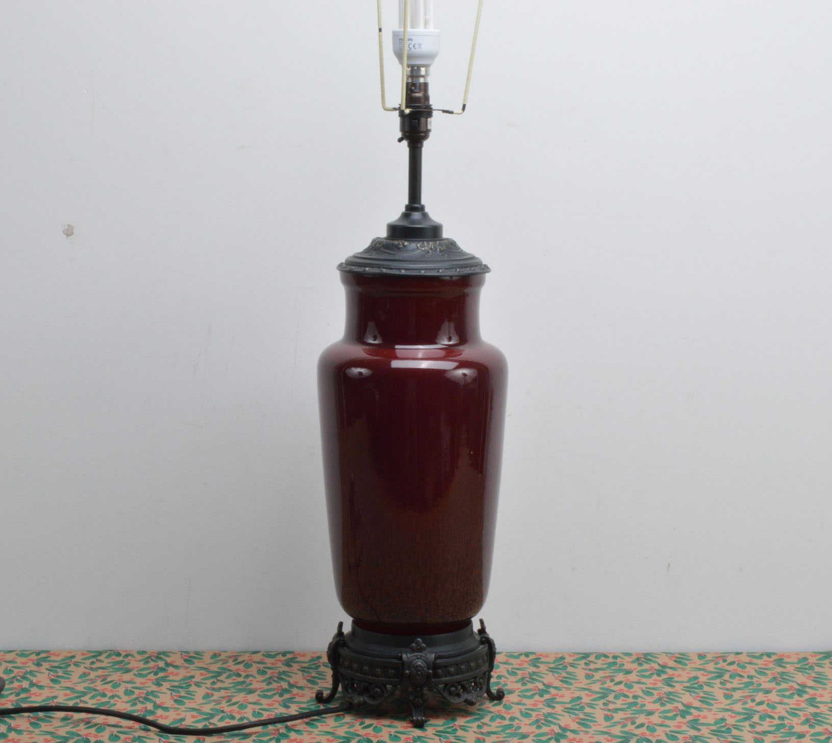 A modern pottery table lamp, in marroon with metal mounts and having cream shade, 85cm high in total