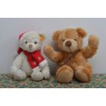 Two modern Steiff yellow tag Teddy bears, one white bear wearing Christmas hat and scarf, the