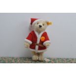 A modern Steiff yellow tag Christmas Teddy bear, blond mohair, known as Noel, on Russ stand, 27cm