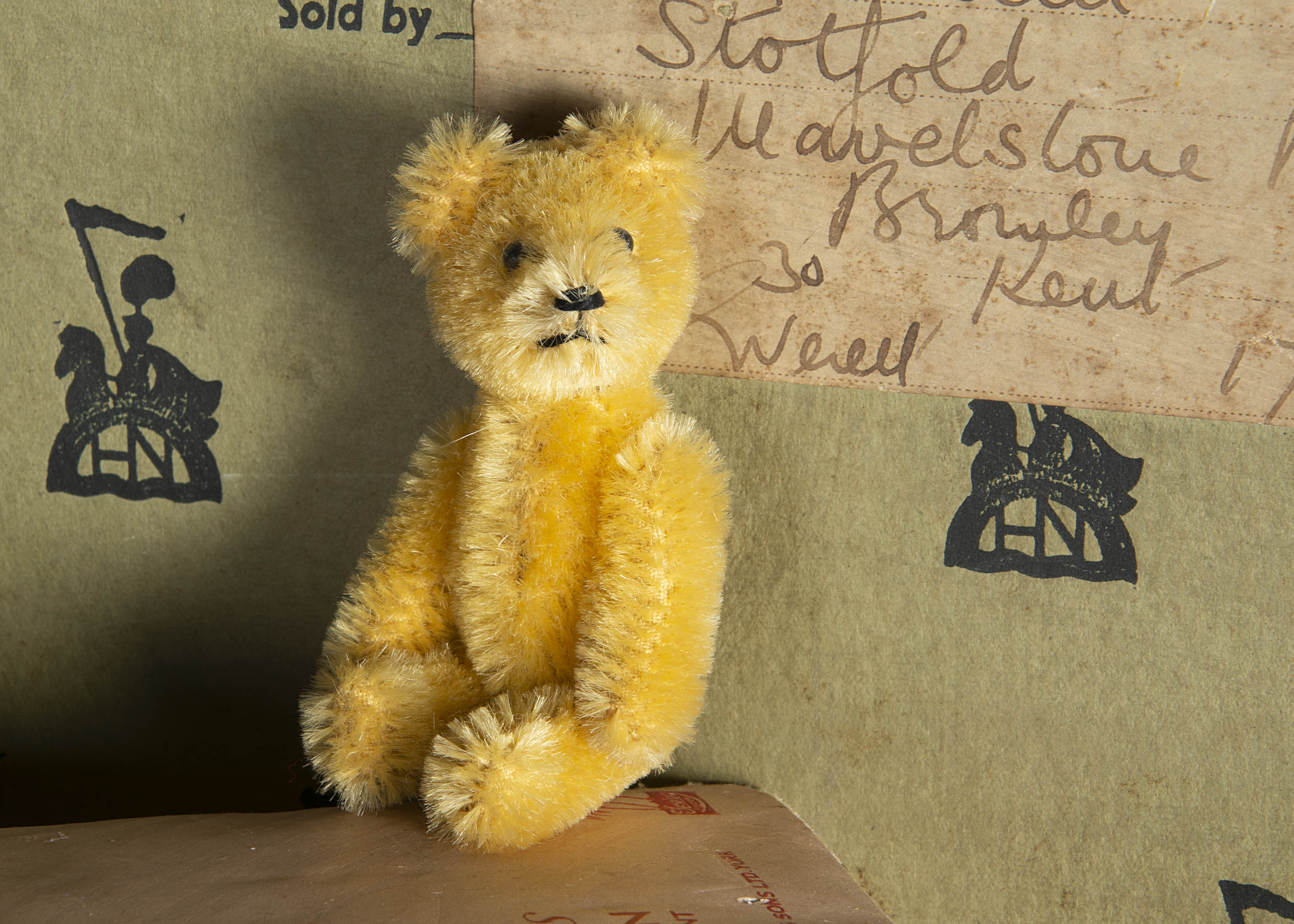 A post-war Schuco miniature Teddy Bear, with light golden mohair, black metal pin eyes, black