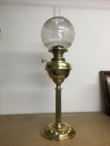 An Art Nouveau brass oil lamp with etched glass sh