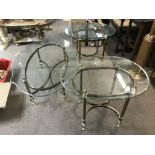 A trio of modern brass and glass tables.