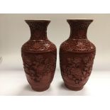 A pair of cinnabar vases decorated with flowers, a