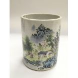 An Oriental brush pot with hand painted landscape