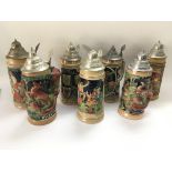 A collection of steins including two depicting woo