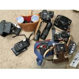 An assortment of cameras, lenses, accessories and binoculars.