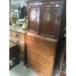 A Mahogany bedroom chest with cupboards above four