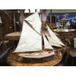 A painted wooden model of a sailing boat, approx length 95cm.