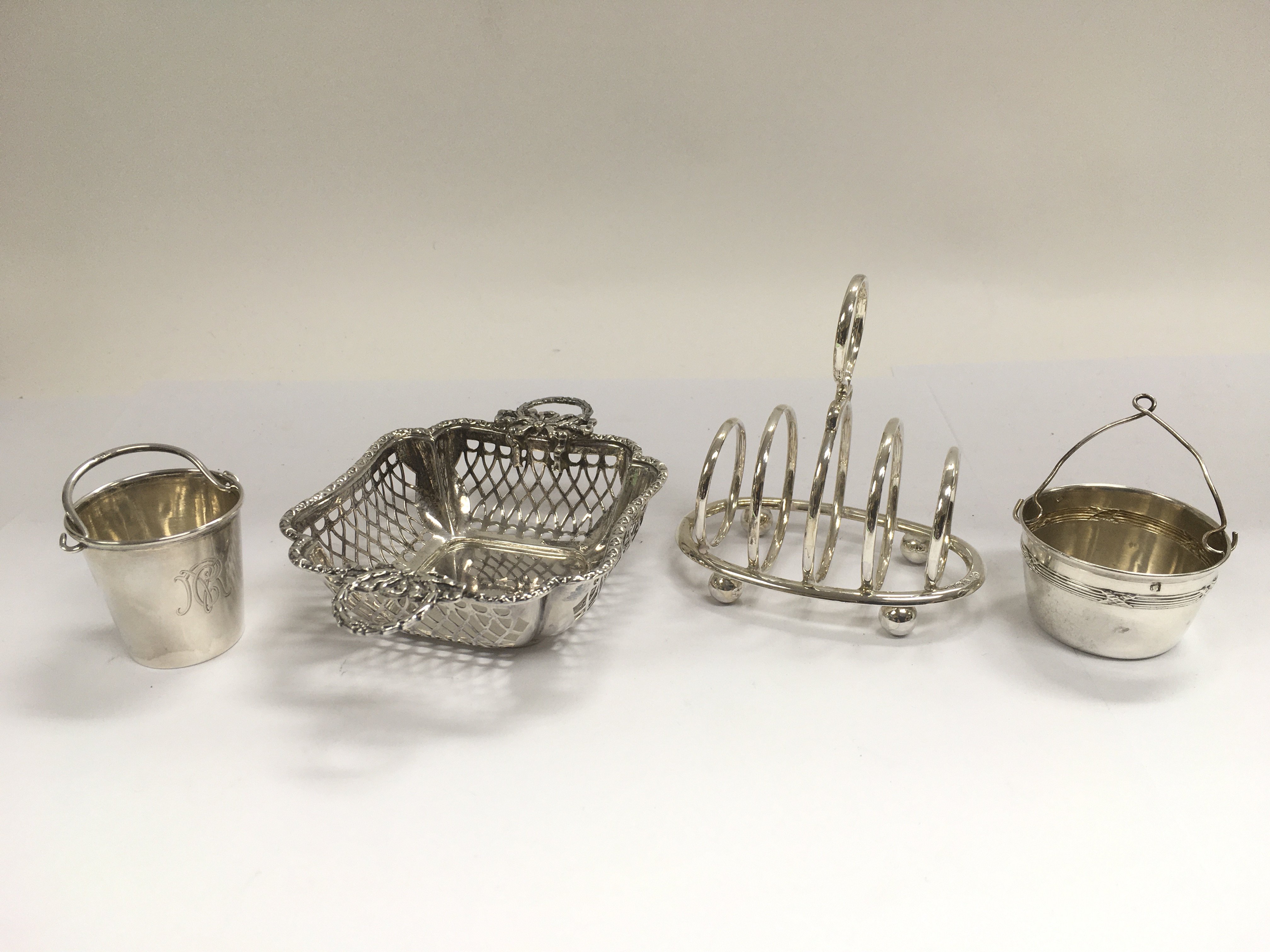 A silver sweet meat basket, toast rack, tea strain