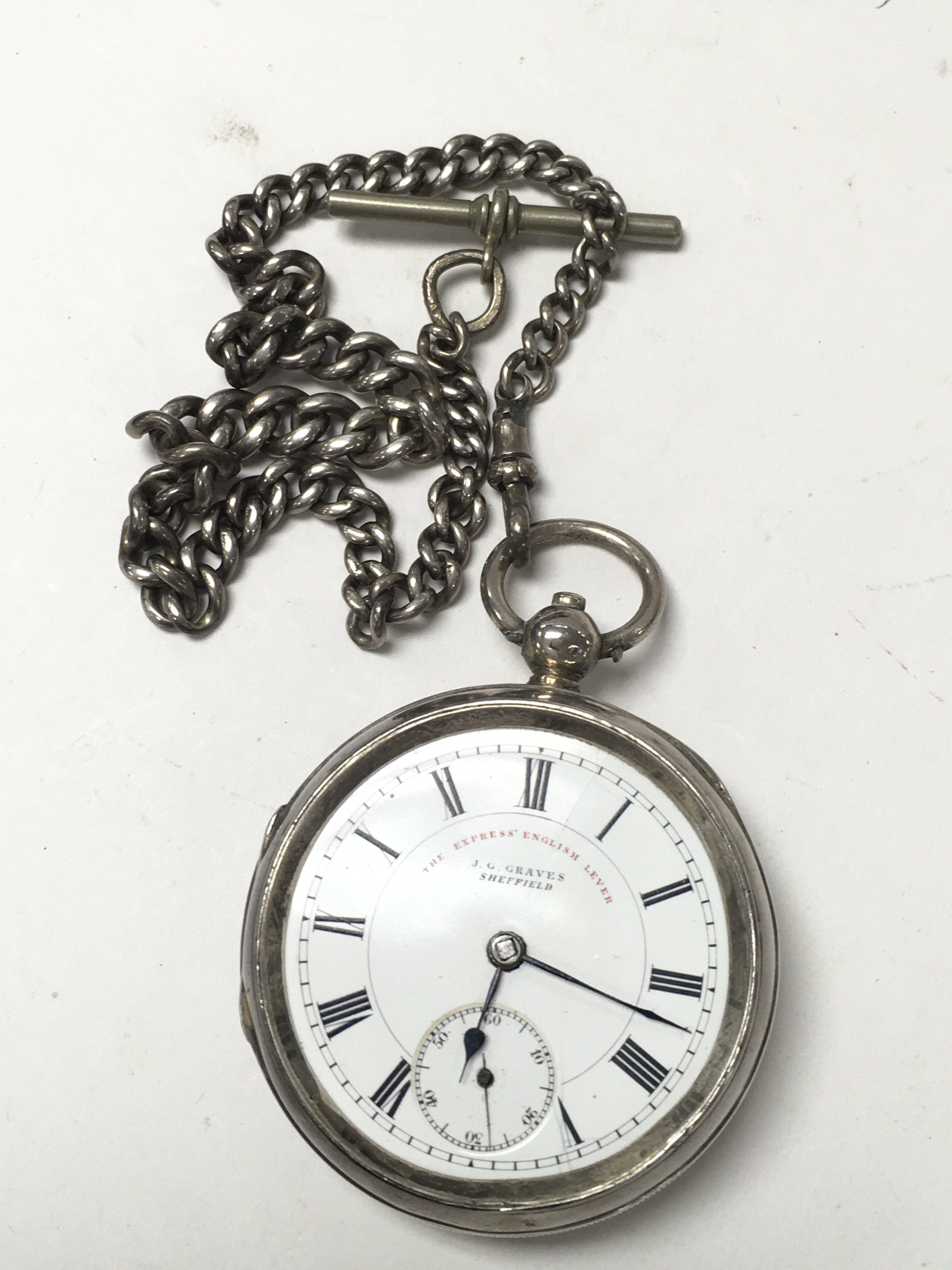 A silver pocket watch with heavy silver chain, cir