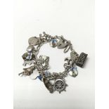 A silver charm bracelet with mainly enamelled char