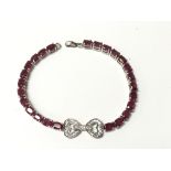 A silver bracelet set with rubies.