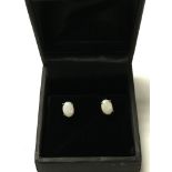 A pair of 9ct rose gold stud earrings set with opa