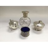 A silver topped perfume bottle and three silver co