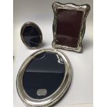 Three silver photo frames of varying sizes.