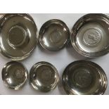 Six silver dishes inset with coins . 430 grams.