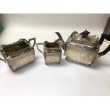 A three part antique silver tea set .